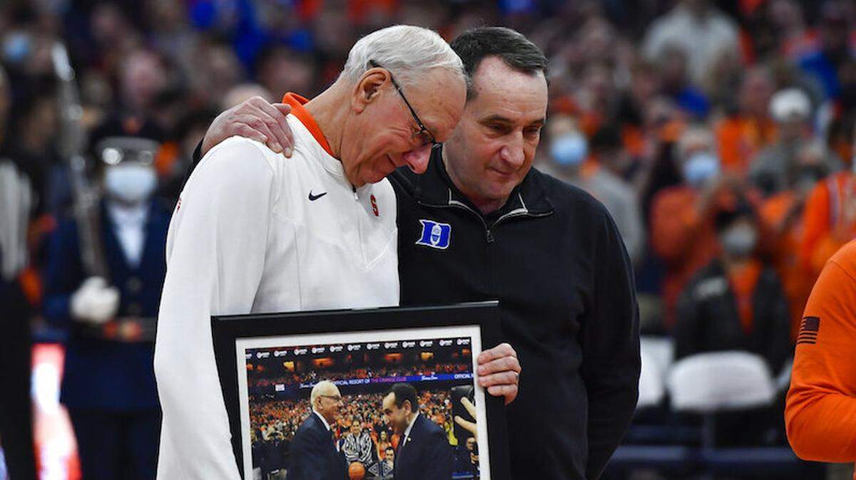 Syracuse coach Jim Boeheim, left, presents Duke coach Mike Krzyzewski with a gift before an NCAA college basketball game in Syracuse, N.Y., Saturday, Feb. 26, 2022. (AP Photo/Adrian Kraus)