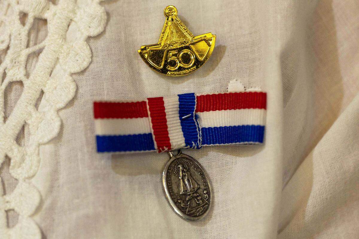 A congregant wears a pin for Our Lady of Charity while worshipping inside Ermita de la Caridad during the annual celebration of the feast day of Cuba's patroness at the National Shrine of Our Lady of Charity, on Monday, September 8, 2025, in Coconut Grove, Fla.