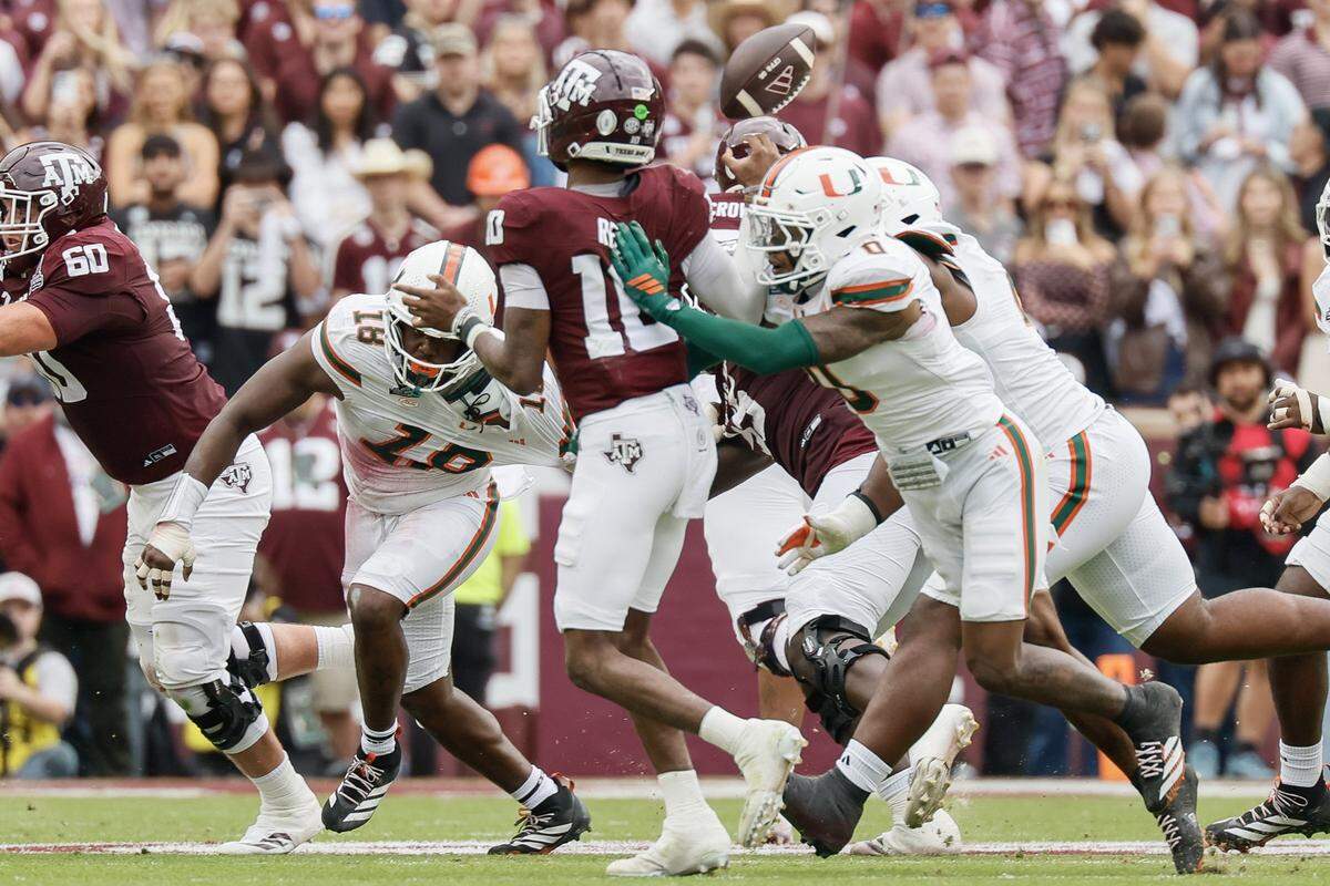 Miami Hurricanes defensive back Keionte Scott (0) and teammates cause Texas A&M Aggies quarterback Marcel Reed (10) to fumble in the first half of the first round of the 2025 College Football Playoff at Kyle Field at College Station, Texas, on Saturday, December 20, 2025.