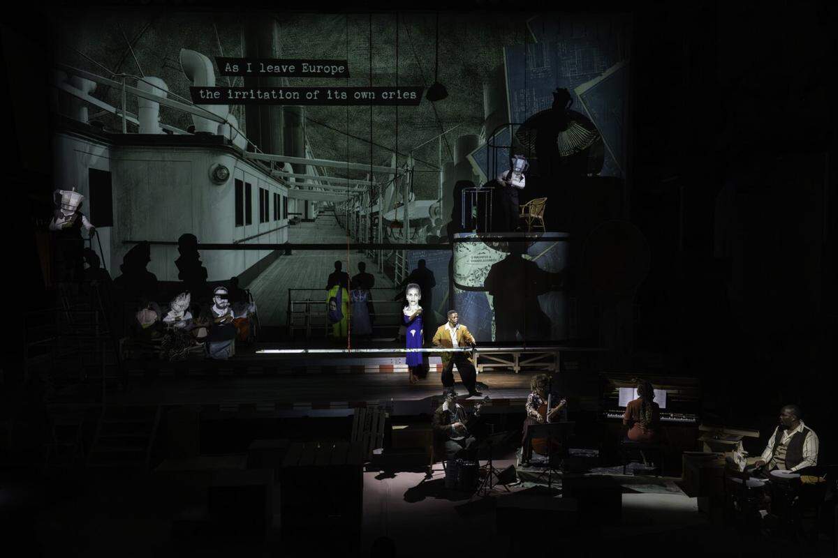 Surrealism’s intersections with the Négritude movement are brought into sharp focus in “The Great Yes, The Great No.” From left are Nancy Nkusi, playing writer Suzanne Césaire and Xolisile Bongwana as her husband, poet and politician Aimé Césaire. Above, on platform: William Harding; Nancy Nkusi on film. 