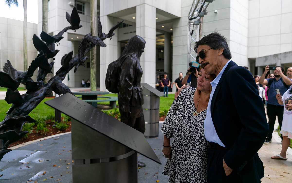 Gina and Orlando Duran, the parents of Alexa Duran, the FIU student killed when the FIU pedestrian bridge under construction collapsed on March 15, 2018, embrace during the unveiling of a sculpture at FIU’s main campus on Tuesday, the four-year anniversary of the crash. Six people were killed in the accident; the sculpture honors Alexa and the five others who died.