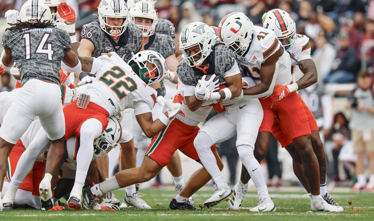 Miami Hurricanes linebacker Chase Smith (41) tackles Virginia Tech Hokies linebacker Caleb Woodson (20) on a kickoff return in the first half at Lane Stadium in Blacksburg, Virginia, on Saturday, November 22, 2025.