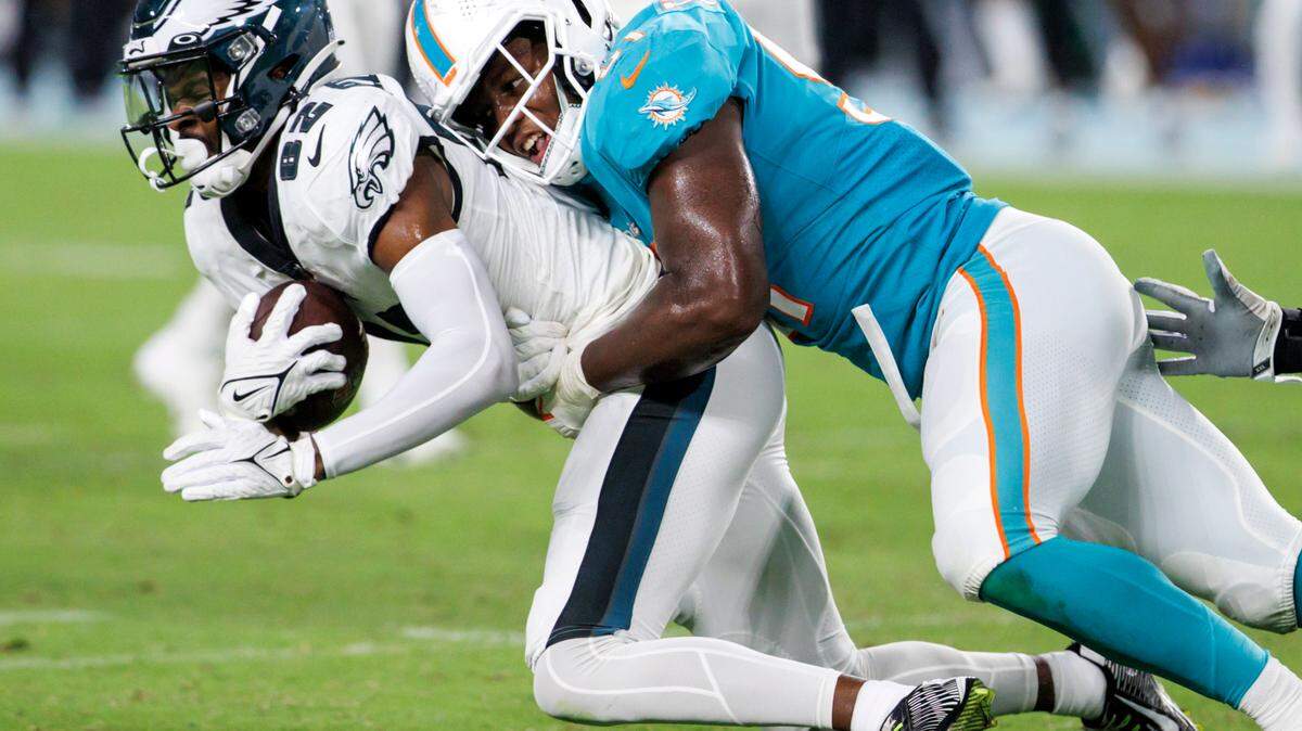 Miami Dolphins linebacker Channing Tindall (51) takes Philadelphia Eagles wide receiver John Hightower (82) during fourth quarter of an NFL preseason football game at Hard Rock Stadium on Saturday, August 27, 2022 in Miami Gardens, Florida.