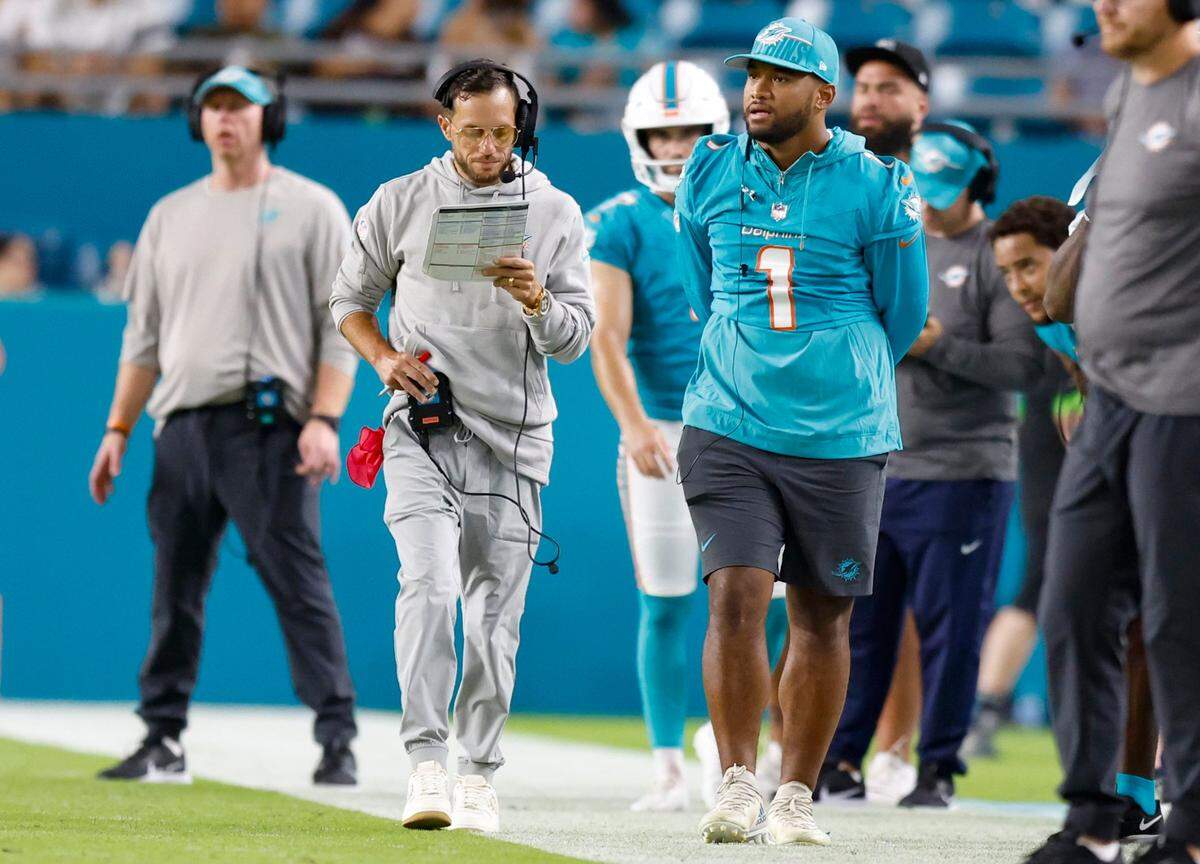 Miami Dolphins quarterback Tua Tagovailoa (1) walks along the sideline with coach Mike McDaniel during a preseason game against the Atlanta Falcons at Hard Rock Stadium in Miami Gardens on Friday, August 11, 2023.