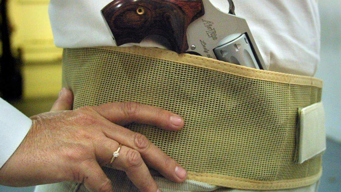 In a file photo, a woman wears a weapon partially concealed in a belly band.