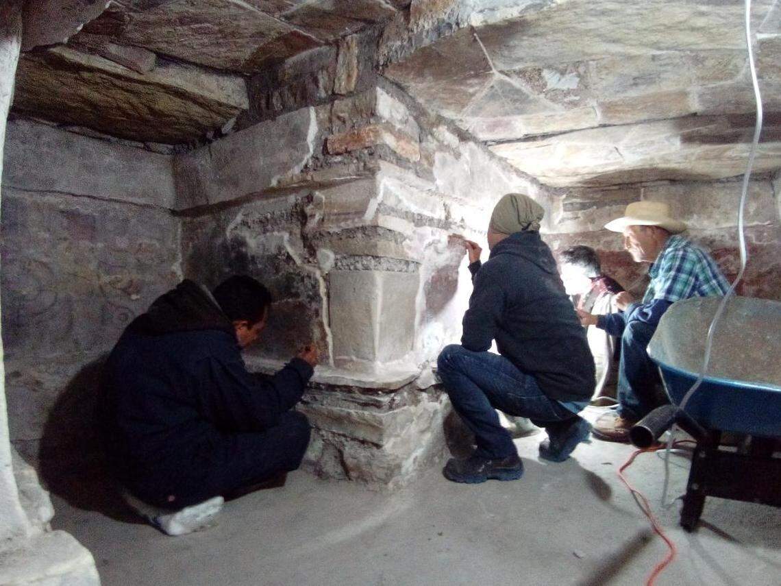 Archaeologists working to restore the tomb and murals.