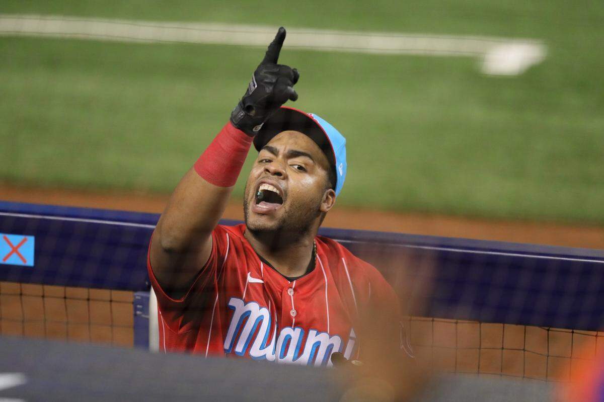Miami Marlins first baseman Jesus Aguilar (24) interacts with a fan from the dugout during baseball game against the New York Mets at loanDepot park in Miami on Friday, May 21, 2021.