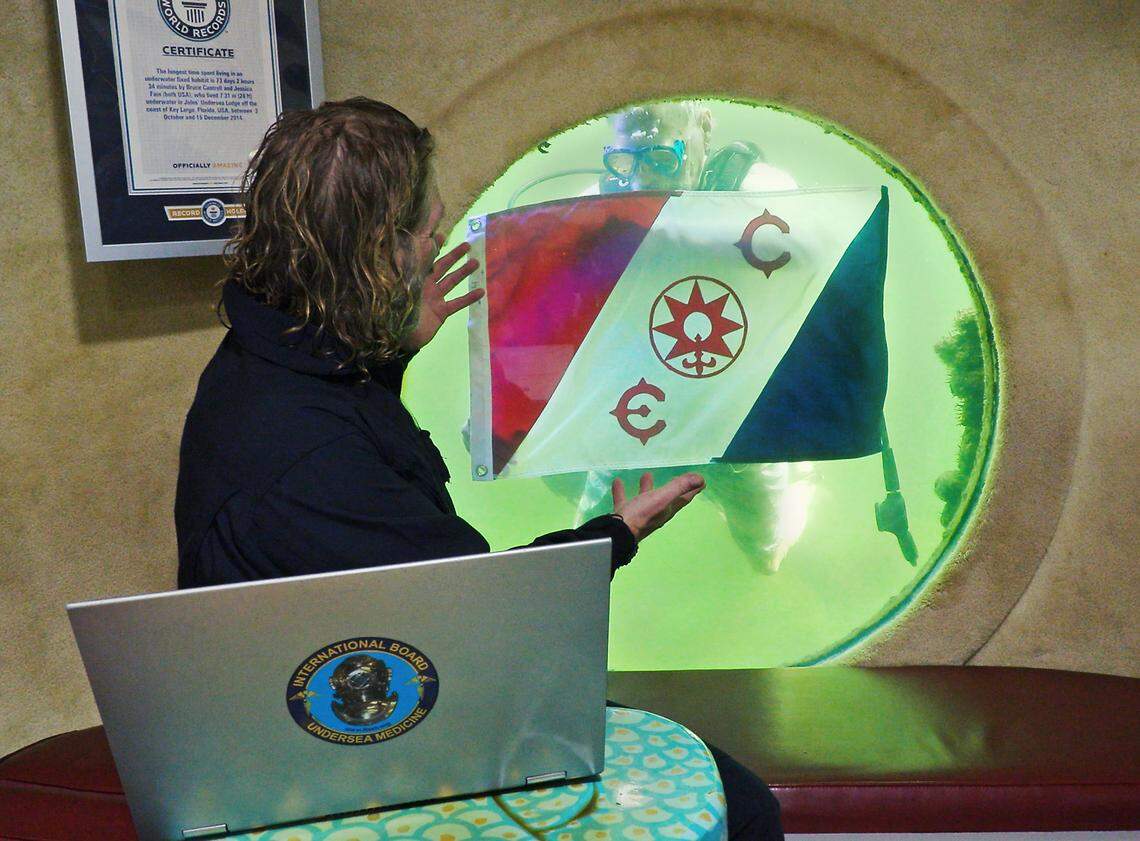 Dr. Joseph Dituri peers out of a large porthole from inside Jules’ Undersea Lodge, located 30 feet below the surface in a Key Largo lagoon, on Wednesday, March 1, 2023.