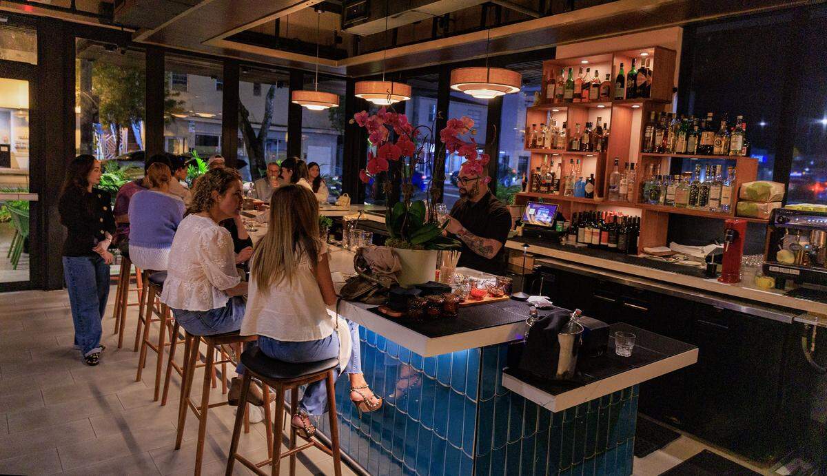 Sachi Statz (far right) Chef/Owner shares with patrons as bartender Alex Carro mixes some drinks at the bar of the recently opened Tin Tin, Cuban Cuisine Restaurant in Little Havana, on Friday January 09, 2026.