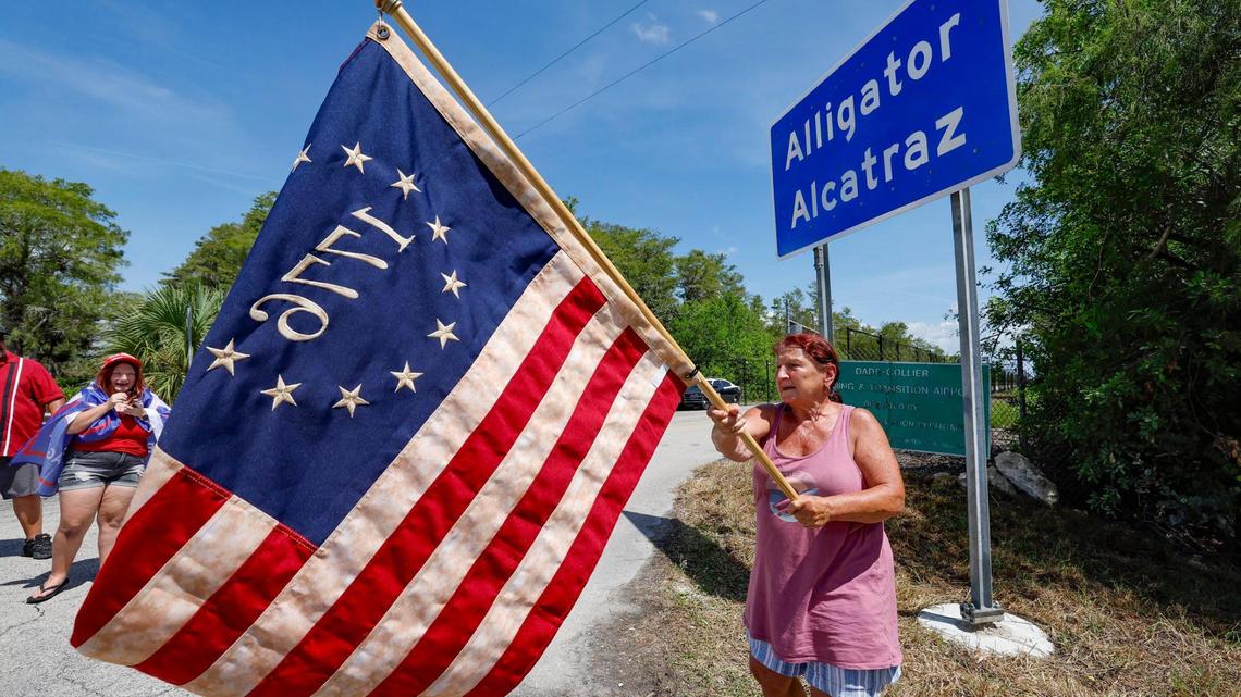 Rena Mourer, who is in favor of Alligator Alcatraz, waves a Betsy Ross 1776 American flag at the front entrance to Alligator Alcatraz as Florida lawmakers and members of Congress tour the detention facility located within the Florida Everglades, 36 miles west of the central business district of Miami, in Collier County, Florida Saturday, July 12, 2025.