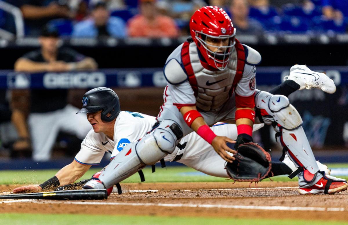 Miami Marlins base runner Peyton Burdick (6) slides into home plate to score a run off a Joey Wendle hit as Washington Nationals catcher Keibert Ruiz (20) waits for the throw during the second inning of an MLB game at loanDepot park in the Little Havana neighborhood of Miami, Florida, on Tuesday, May 16, 2023.