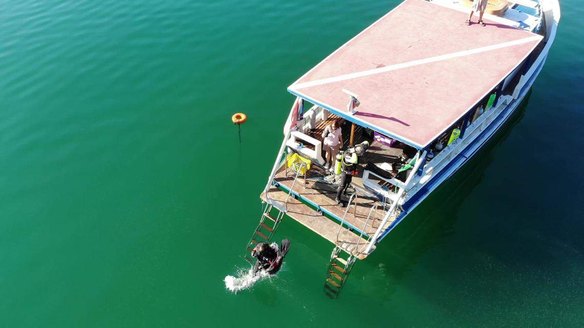 A scuba diver jumps off the boat during a research expedition.