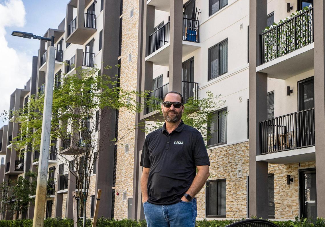 Alex R. Ballina, Director of Governmental & Public Affairs, at the Resia apartment operator stands in front of a building at the Oak Enclave complex in Miami Gardens, on Thursday July 14, 2022.