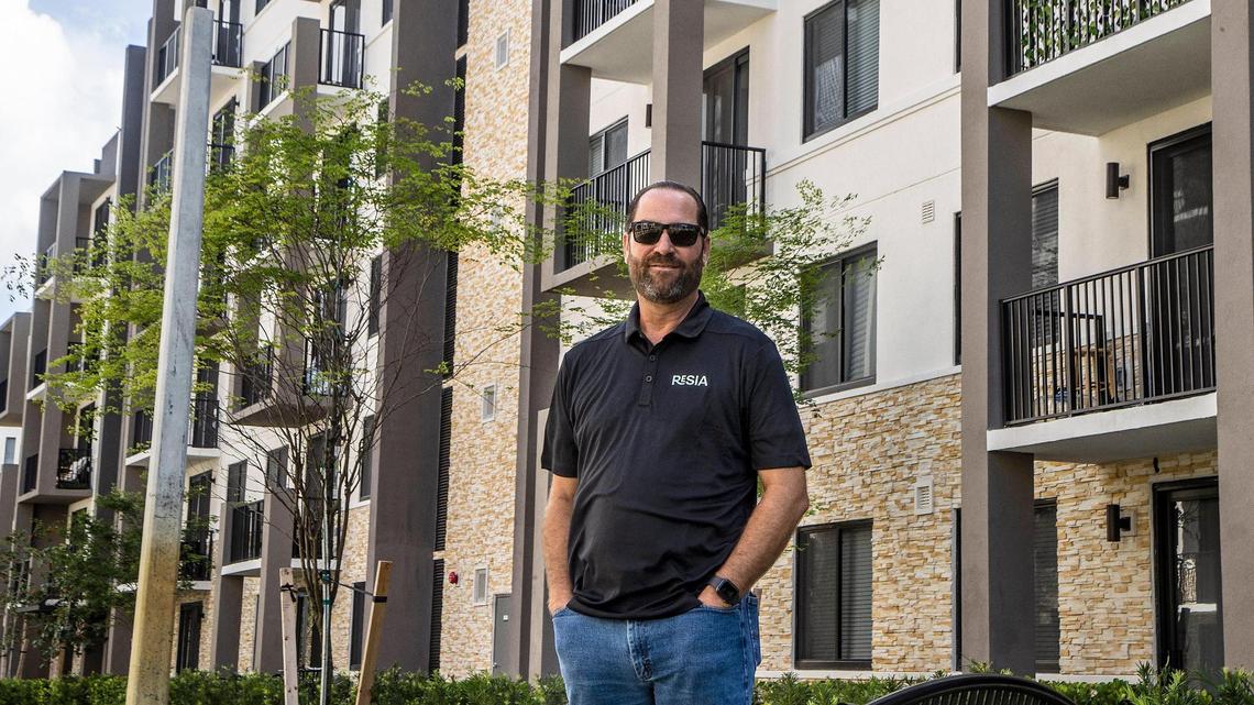 Alex R. Ballina, director of Governmental & Public Affairs, at AHS Residential stands in front of a building at the Resia Oak Enclave complex in Miami Gardens, on Thursday July 14, 2022.
