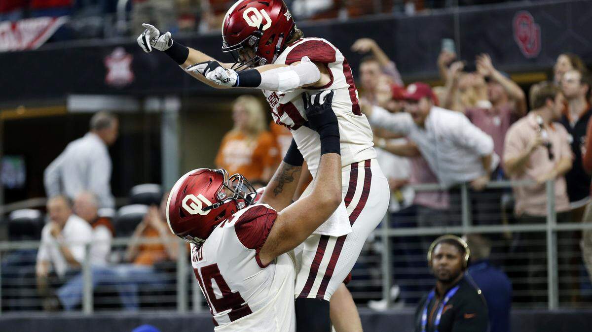 Oklahoma Sooners tight end Grant Calcaterra (right) celebrates a touchdown with offensive tackle Cody Ford (left) during the first half of the NCAA Big 12 Conference football championship against the Texas Longhorns, Saturday, Dec. 1, 2018, in Arlington, Texas. Oklahoma defeated Texas 39-27.