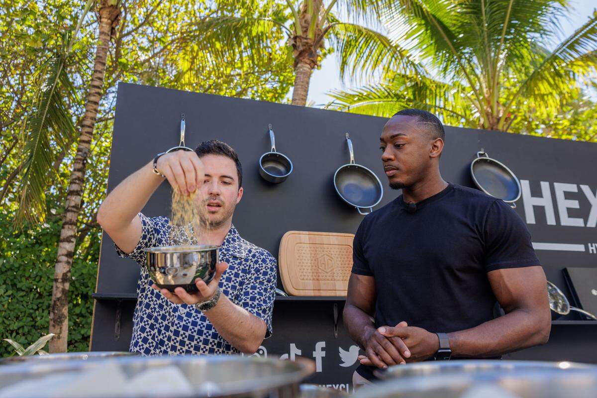 Nico Norena (@succulentbite) and Robert Lucas (@thesweetimpact) participate in a cooking demonstration at the 2023 FoodieCon at the South Beach Wine & Food Festival.