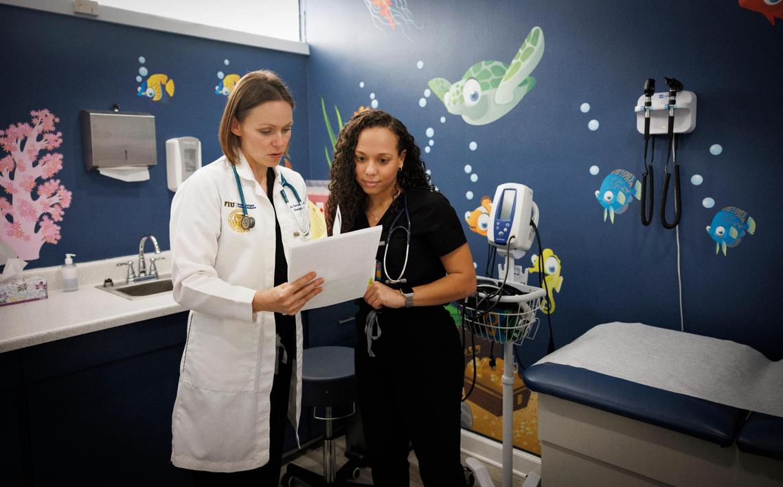 Dr. Kate Semidey, left, talks to Daniela Vasquez, fourth year medical student, about a patients treatment plan during the day on Monday, Dec. 16, 2024, inside the UHI CommunityCare Clinic in Opa-locka, Fla.