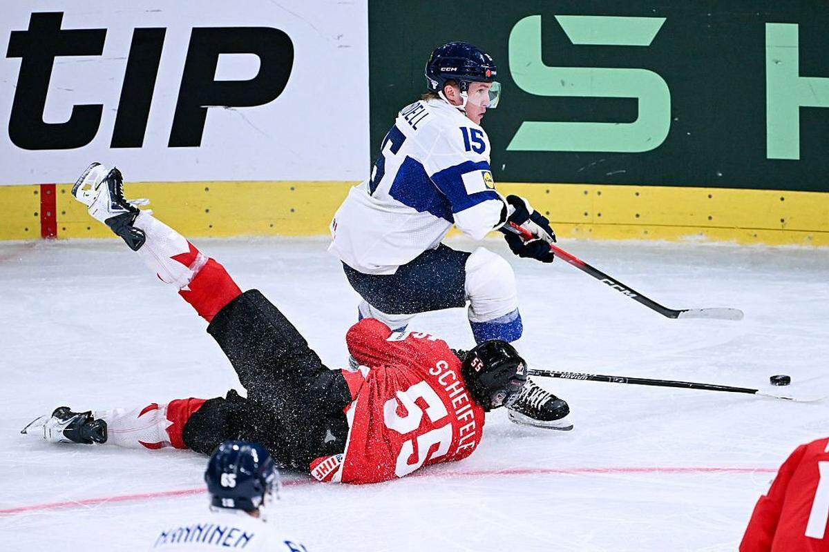 Finland's forward #15 Anton Lundell and Canada's forward #55 Mark Scheifele (L) fight for the puck during the IIHF Ice Hockey Men's World Championship semi-final match between Canada and Finland at the Swiss Life Arena in Zurich, on May 30, 2026. (Photo by Fabrice COFFRINI / AFP via Getty Images)