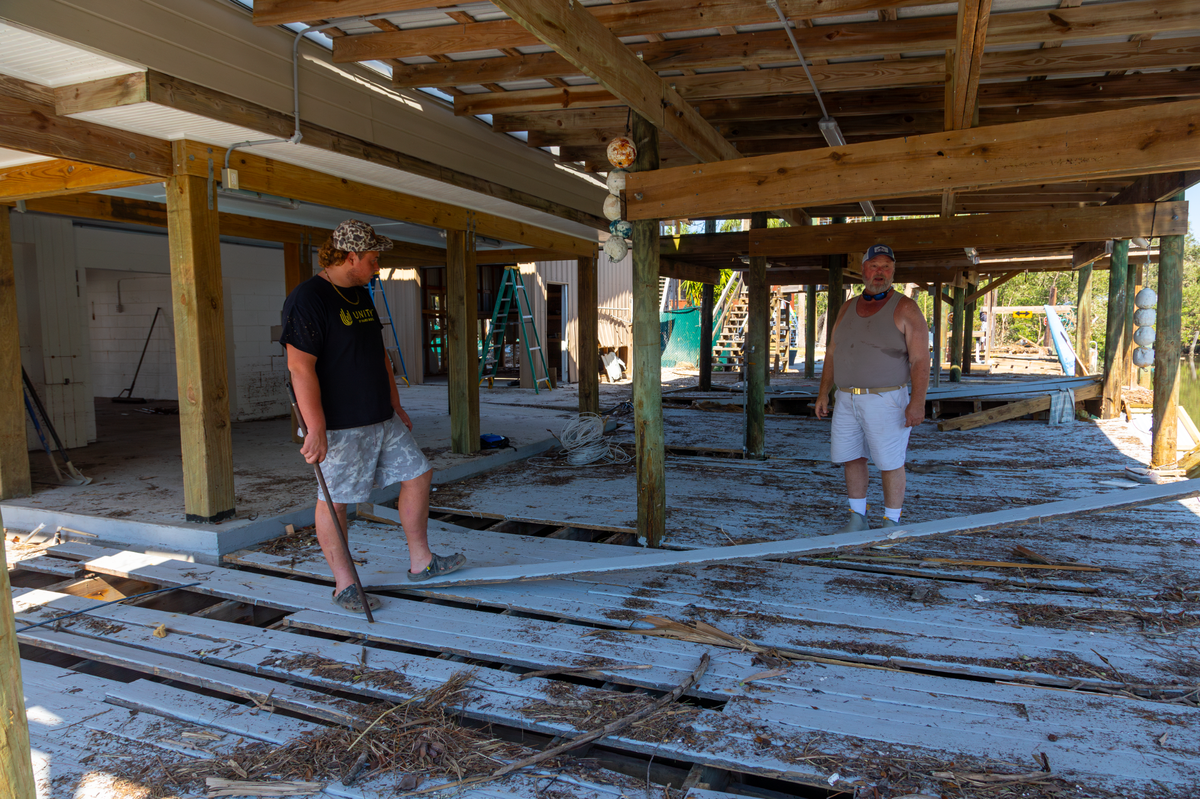 Jeff and Jeffery Schleede survey the damage to their back deck in Cedar Key on Wednesday, Oct. 2.