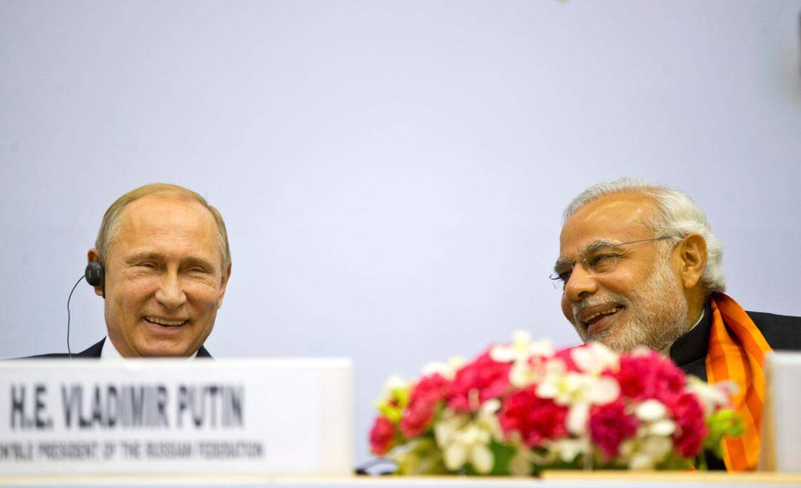 Indian Prime Minister Narendra Modi, right, and Russian President Vladimir Putin share a laugh as they attend a session of the World Diamond Conference in New Delhi, India, Thursday, Dec. 11, 2014. (AP Photo/ Saurabh Das)