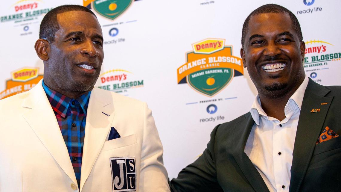 Jackson State University head coach Deion Sanders, left, and Florida A&M University head coach Willie Simmons, right, interact during a pregame press conference for the Orange Blossom Classic held on the Club Level at Hard Rock Stadium in Miami Gardens, Florida, on Friday, September 2, 2022.