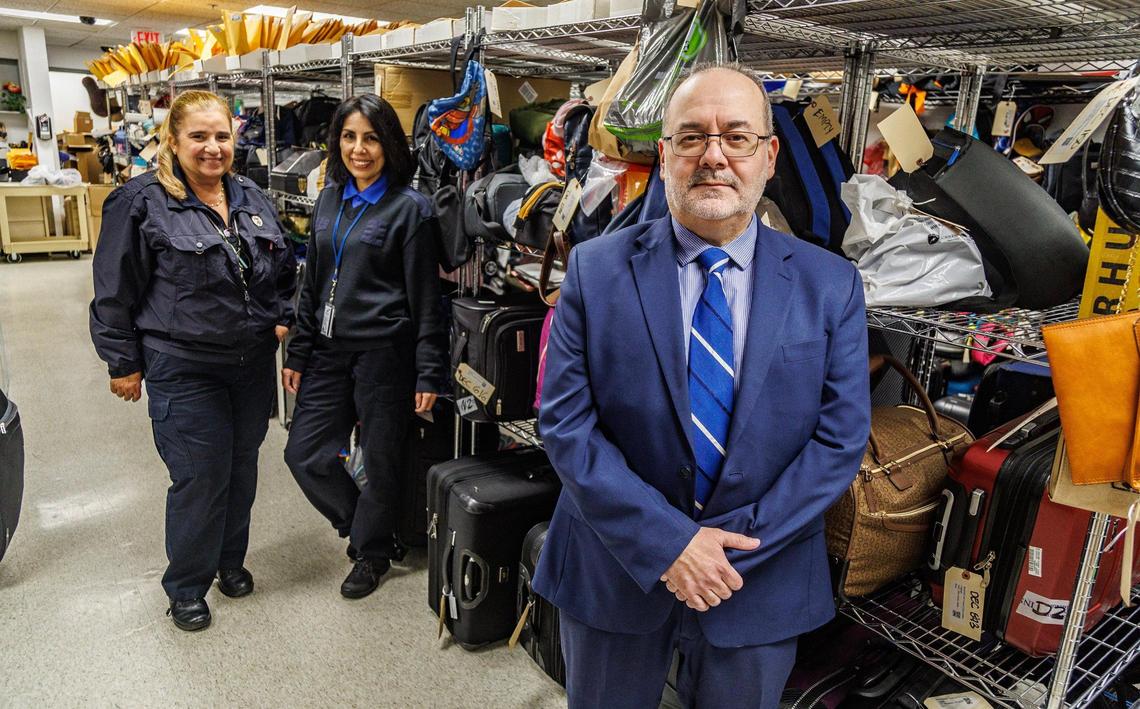 Evelio Zuriarrain, Terminal Operations Supervisor, withnstaff members Agent Leticia Luna (far left) and Specialist Miriam Marroquin, posed in the Lost and Found department at Miami International Airport, on Tuesday December 13, 2023.