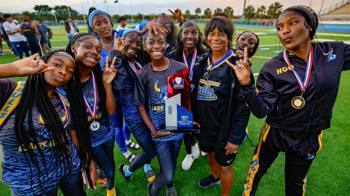 Miami Northwestern’s Lamia Green holds the championship trophy as the team celebrates during GMAC Track and Field Finals at Traz Powell Stadium in Miami, Florida on Thursday, April 10, 2025.