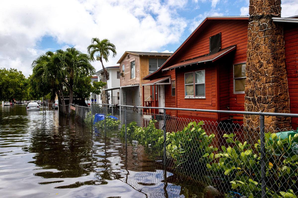 Homes surrounded by knee-high floodwaters off Southwest Fourth Street and Eighth Avenue in the Little Havana neighborhood of Miami, Florida, on Saturday, June 4, 2022. Flooding will become more common as sea level rises, and Miami-Dade may eventually have to buy out flood-prone homes.