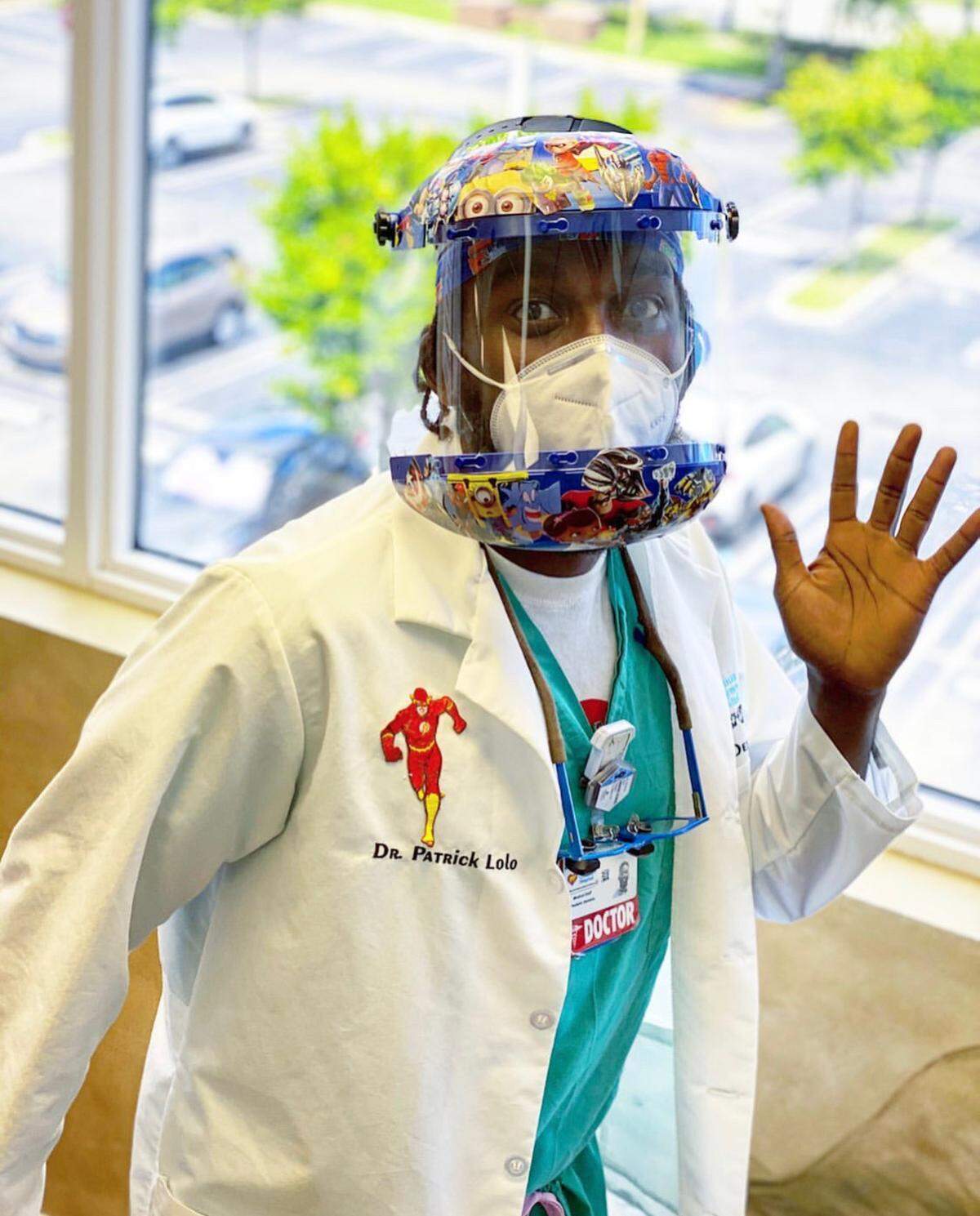 Dr. Patrick S. Lolo, a pediatric dentist at Nicklaus Children’s Hospital in Coral Terrace, poses in ADA-reccomended personal protective equipment, including a decorated helmet and face shield, an N95 mask and eye protection.