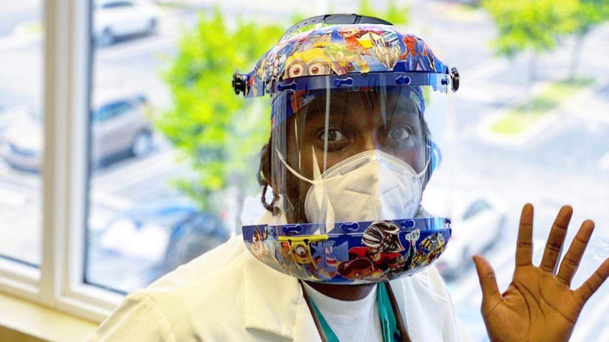 Dr. Patrick S. Lolo, a pediatric dentist at Nicklaus Children’s Hospital in Coral Terrace, poses in ADA-recommended personal protective equipment, including a decorated helmet and face shield, an N95 mask and eye protection.