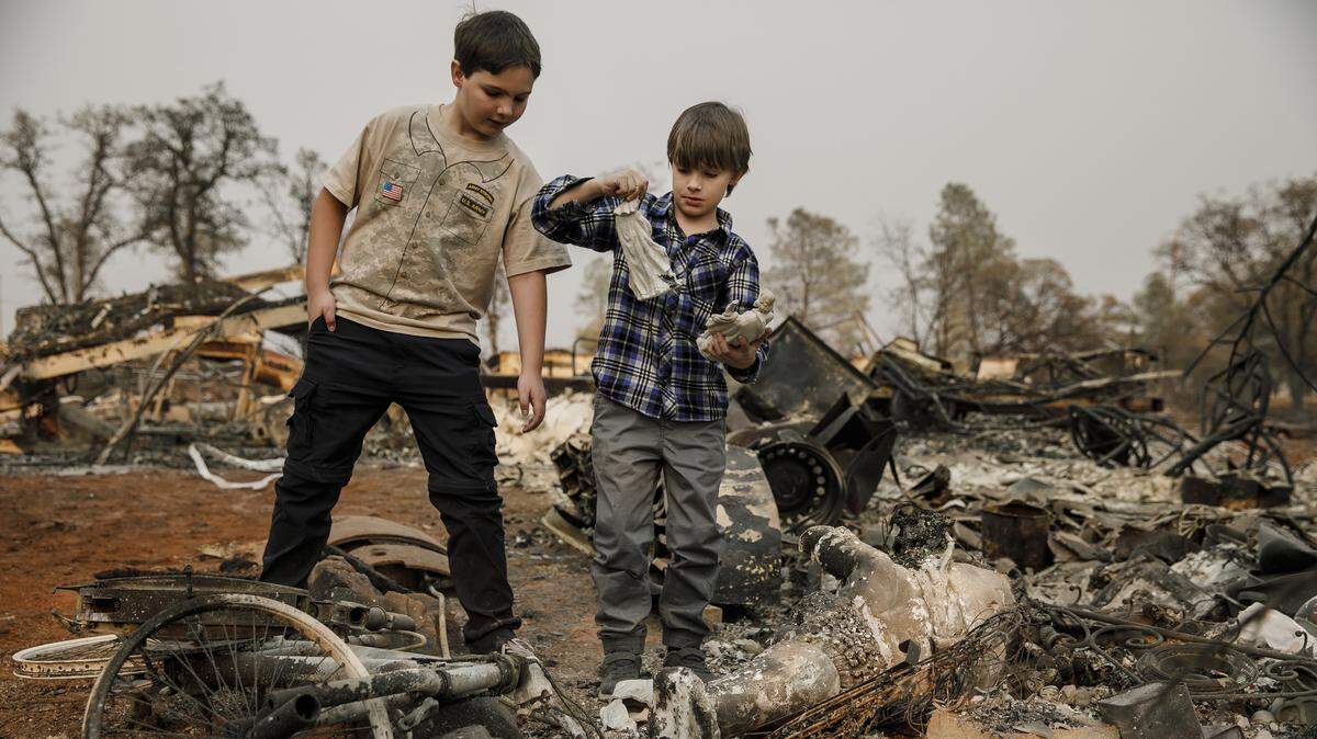 Jacob Saylors, 7, center, with his brother Jeremy Saylors, 11, finds religious figurines still intact as they comb through the rubble for personal items that survived the Camp Fire in Paradise, Calif., on Nov. 18, 2018. The family’s home was also destroyed by another wildfire 10 years ago.