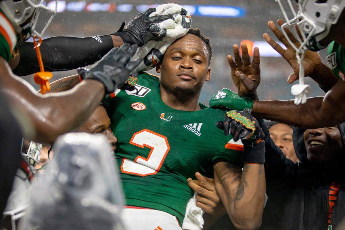 Miami Hurricanes wide receiver Michael Harley (3) celebrates with the touchdown rings on the UM sideline along with teammates during the third quarter of a football game against Louisville at Hard Rock Stadium in Miami Gardens, Florida on Saturday, November 9, 2019.