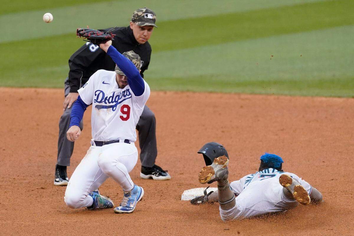 Miami Marlins’ Jazz Chisholm Jr., right, steals second base as Los Angeles Dodgers shortstop Gavin Lux (9) loses control of the ball during the seventh inning of a baseball game Sunday, May 16, 2021, in Los Angeles. (AP Photo/Ashley Landis)