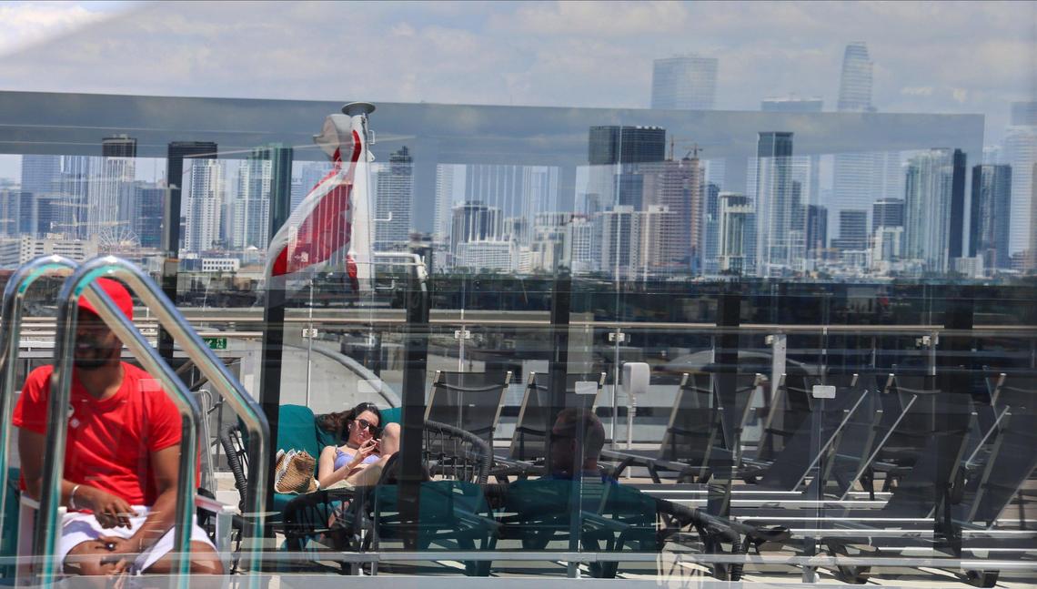 Travelers on the MSC World America catch some sun to the backdrop of the downtown Miami skyline.