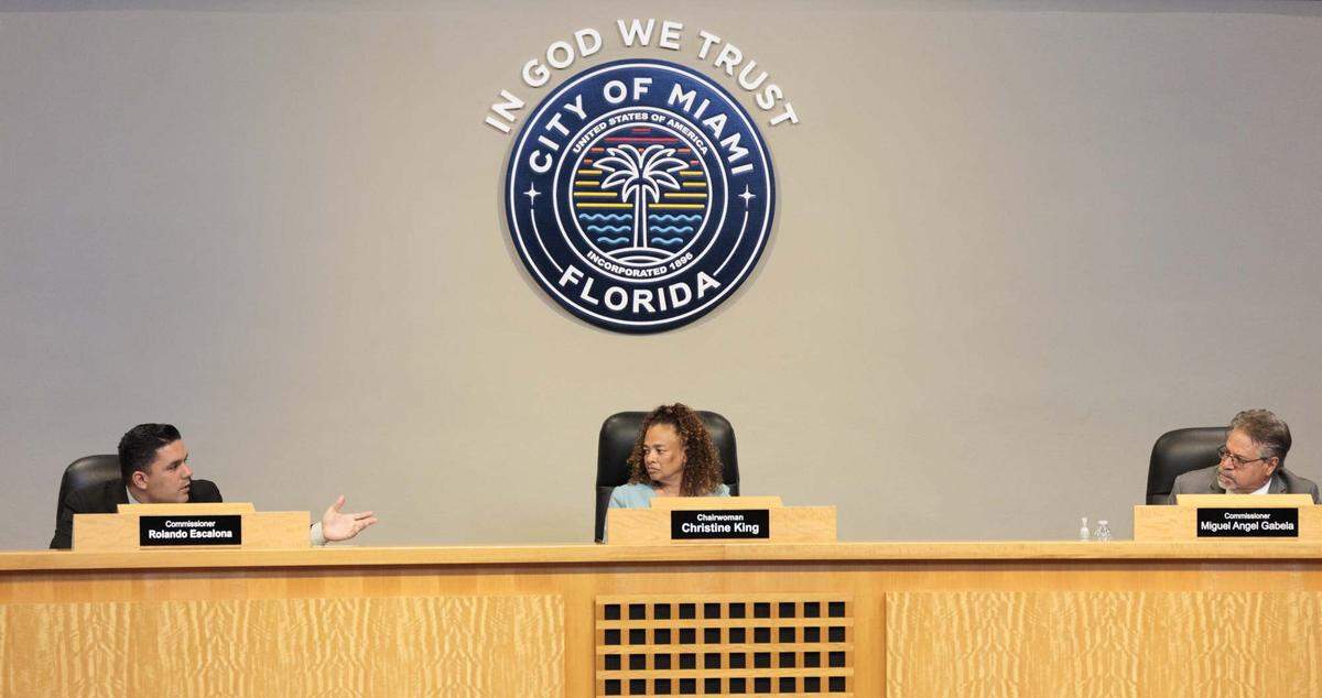 Commissioners Rolando Escalona, left, Christine King, center and Miguel Gabela talk during a Miami City Commission meeting on Thursday, May 14, 2026, at Miami City Hall in Miami, Fla. Mayor Higgins' $450 million bond for police and fire stations was discussed.