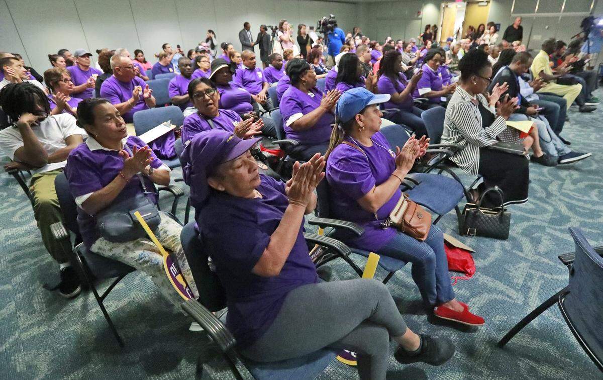 Airport workers applaud as they listen during a round table discussion on hazardous conditions at Miami International Airport, Wednesday, April 24, 2019, in Miami. Workers spoke about inhumane, dangerous working conditions, broken-down airport vehicles and roach infestations they must work with. (AP Photo/Wilfredo Lee)