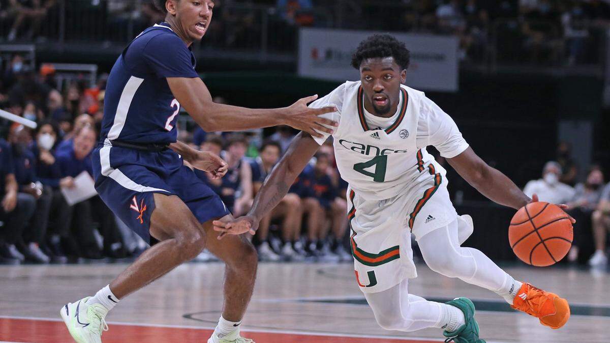 Miami Hurricanes guard Bensley Joseph (4) drives the ball as Virginia Cavaliers guard Reece Beekman (2) defends in the second half at the Watsco Center in Coral Gables on Saturday, February 19, 2022.