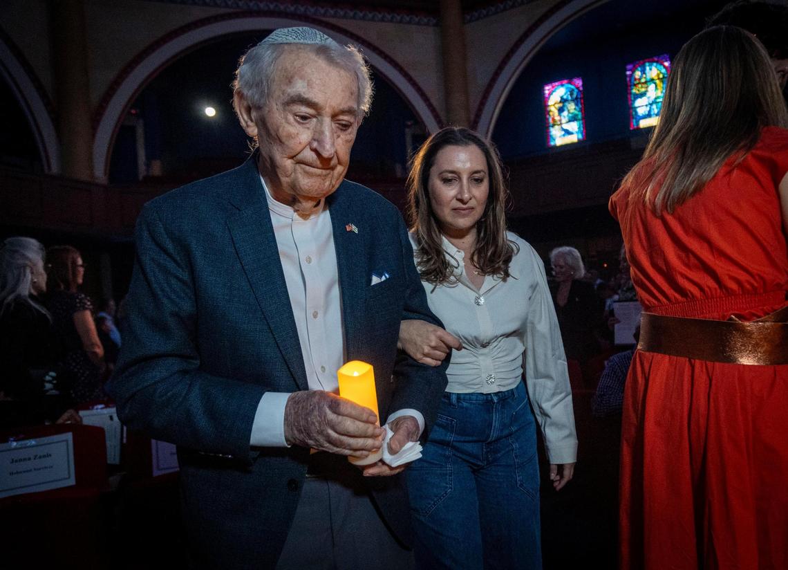 Miami Beach, FL, April 27, 2025 - Holocaust survivor David Schaecter, left, carries a candle as he walks in a procession of Holocaust Survivors into a ceremony to Commemorate Yom HaShoah, Holocaust Remembrance Day at Temple Emanu-El in Miami Beach.
