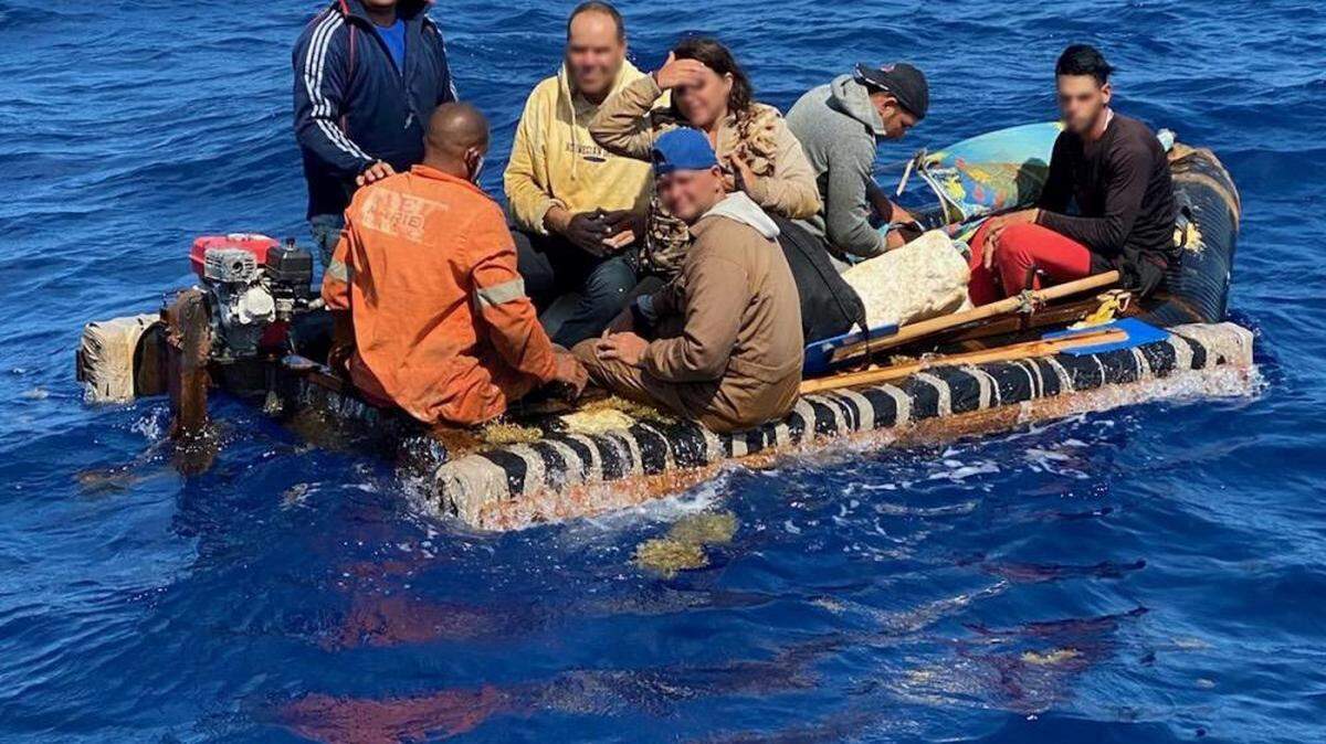 Several people crown on to a small raft floating about 10 miles south of Key West Saturday, May 7, 2022. The people were among 86 people the Coast Guard took back to Cuba Friday, May 13, 2022.