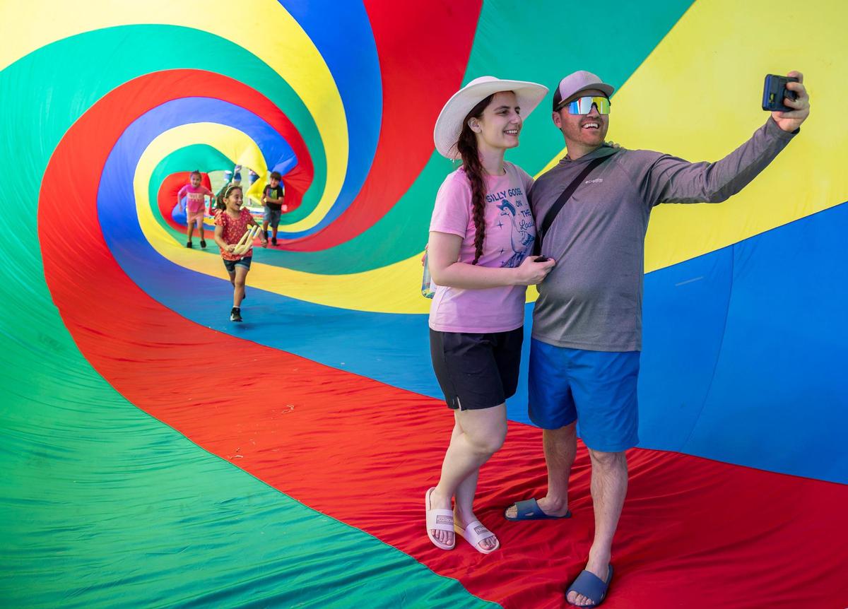 Ilira Ndreu and Almir Zeqo take a selfie inside of a 100-foot spin sock on display at the 33rd Annual Kite Festival in Northeast Miami-Dade on Saturday, Feb. 15, 2025.