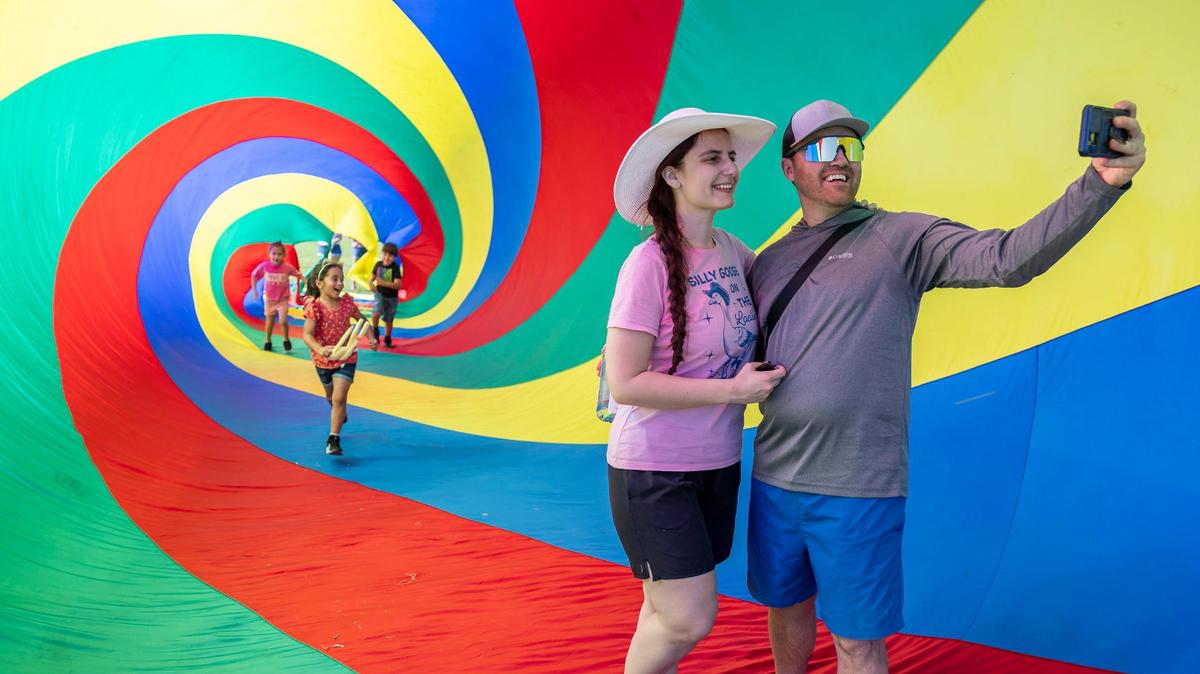 Ilira Ndreu and Almir Zeqo take a selfie inside of a 100-foot spin sock on display at the 33rd Annual Kite Festival in Northeast Miami-Dade on Saturday, Feb. 15, 2025.
