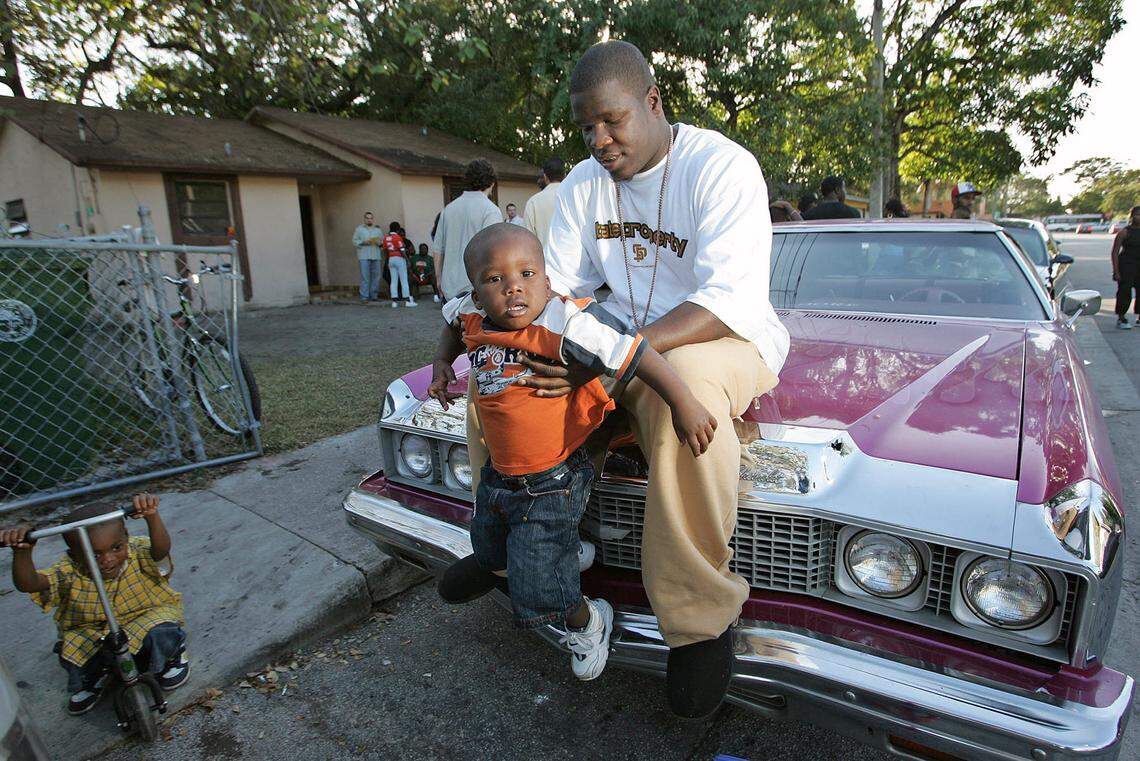 In this 2005 Miami Herald file photo, Frank Gore is seen with his then-2-year-old son Frank Jr. in front of his Coconut Grove home.