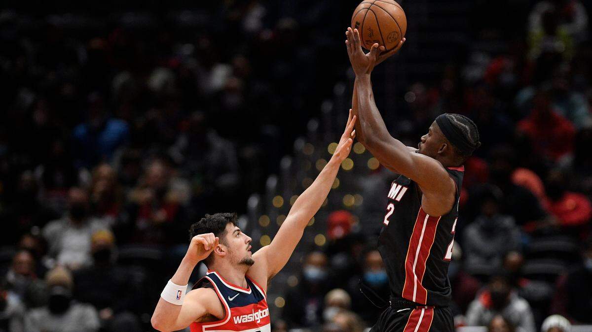 El alero de los Miami Heat Jimmy Butler (22) dispara contra el alero de los Washington Wizards Deni Avdija (9) durante la primera mitad de un juego, el sábado 20 de noviembre de 2021 en Washington.