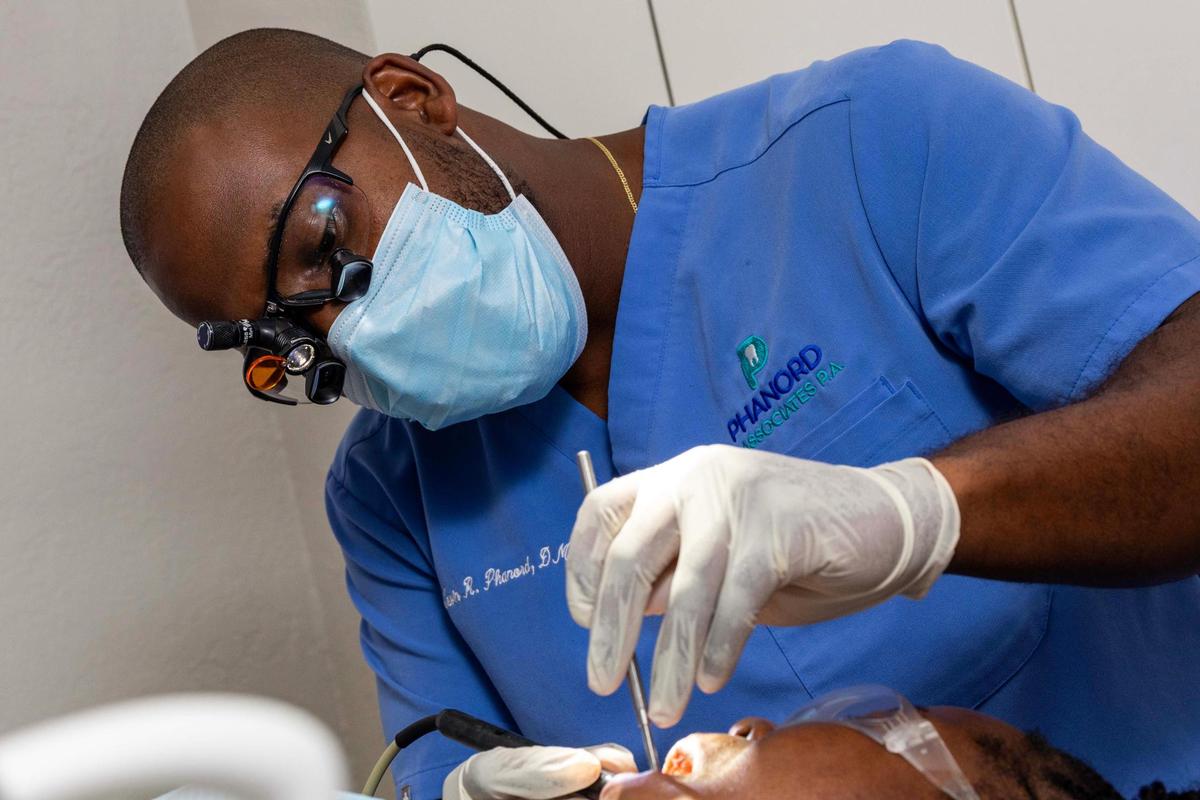 Dr. Kevin R. Phanord works on a patient at his dental practice on Monday, June 9, 2025, in North Miami, Florida.