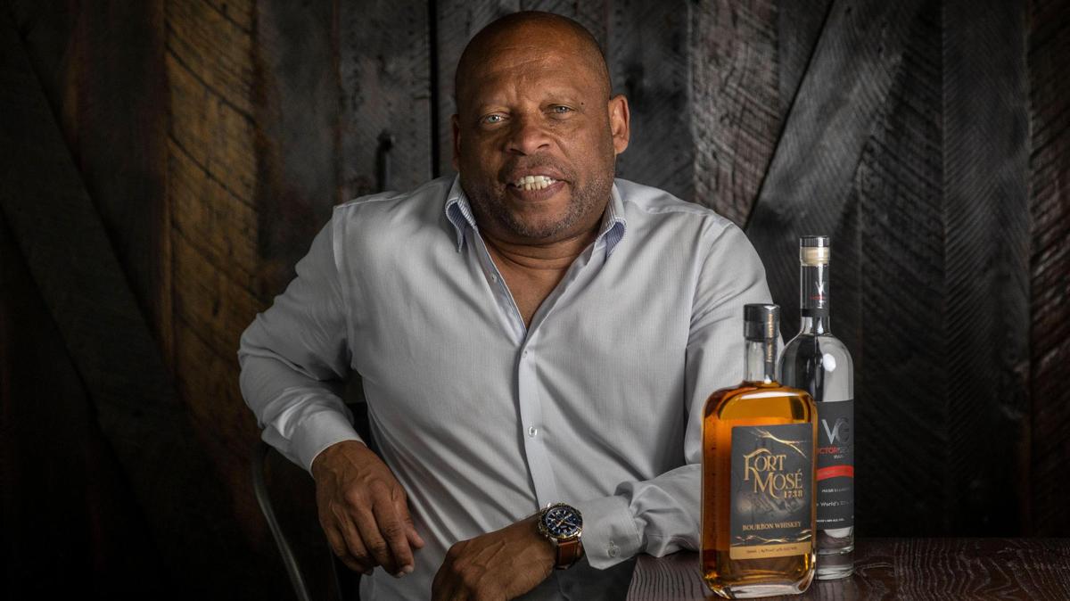 Victor Harvey, owner of Victor George Spirits, shown at his Palm Beach Distillery in West Palm Beach with bottles of the Fort Mosé bourbon and Victor George vodka he produces.