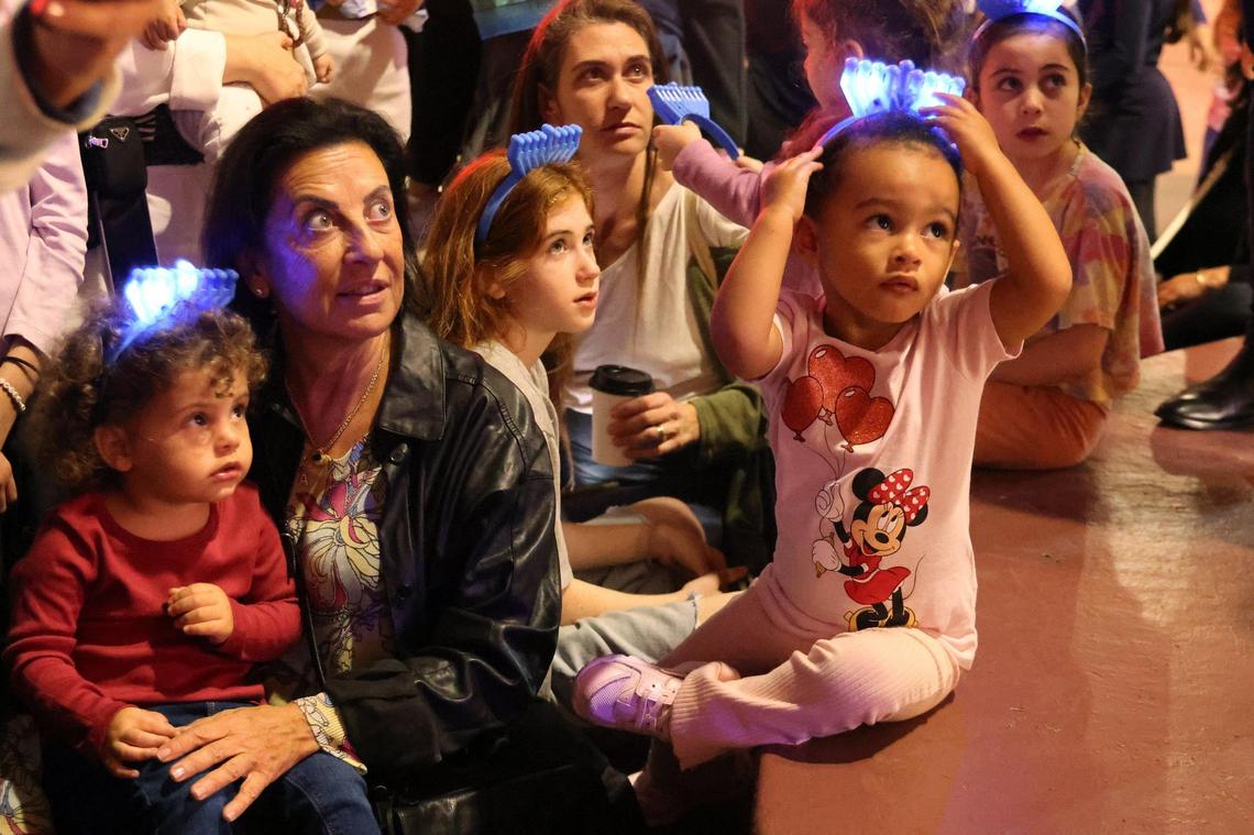 Italian visitors participate in the lighting of the menorah at Lincoln Road and Euclid Circle in Miami Beach on Thursday.