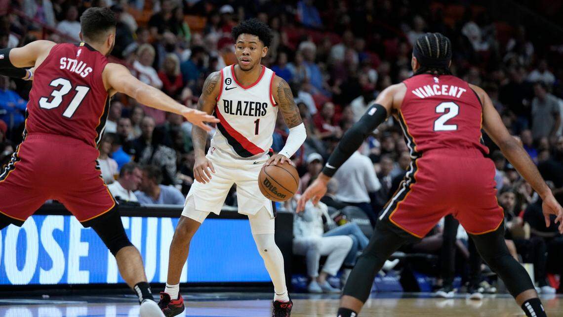 Portland Trail Blazers guard Anfernee Simons (1) looks for an opening past Miami Heat guards Max Strus (31) and Gabe Vincent (2) during the first half of an NBA basketball game, Monday, Nov. 7, 2022, in Miami.