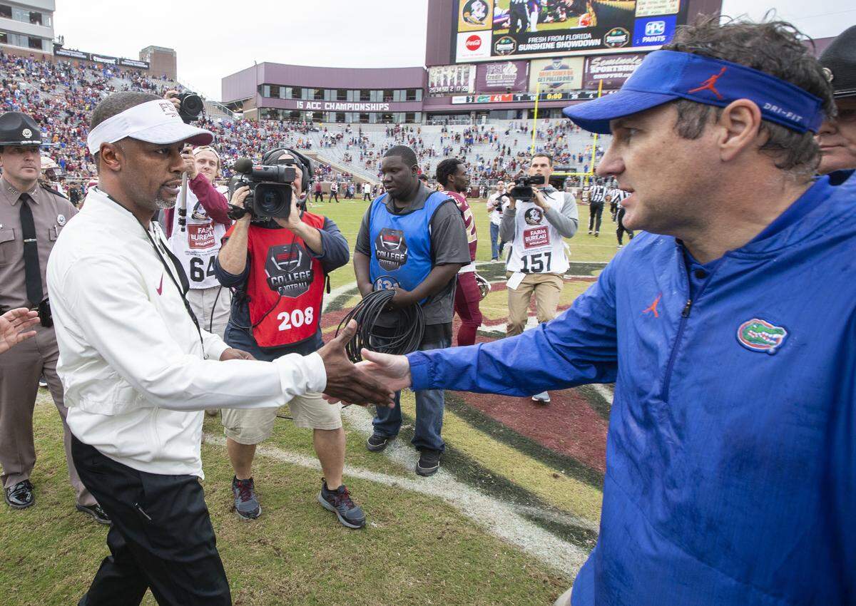 Florida State head coach Willie Taggart, left, and Florida head coach Dan Mullen shook hands after Florida defeated Florida State 41-14 on Nov. 24, 2018.