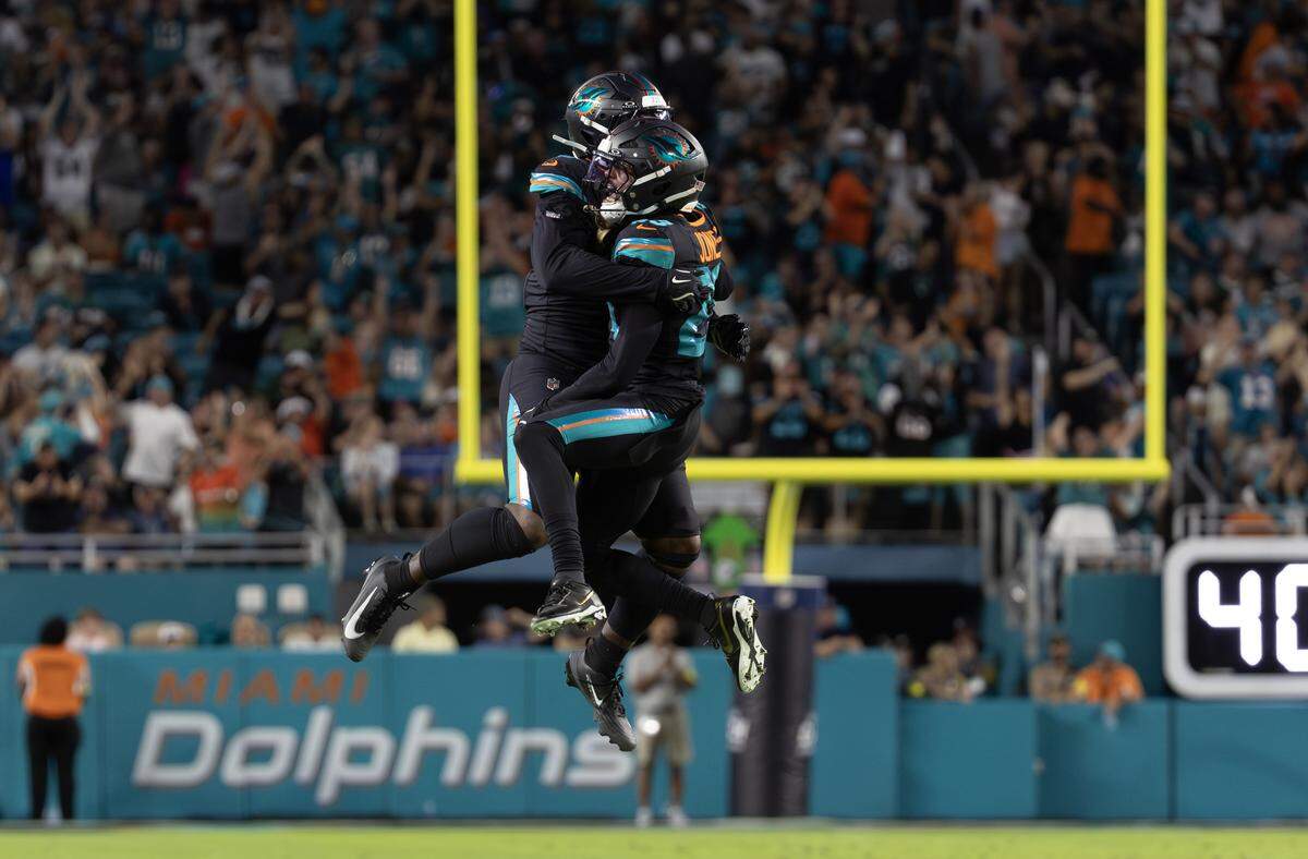 Miami Dolphins cornerback Jack Jones (23) celebrates with linebacker Matthew Judon (8) after forcing a fumble by New York Jets running back Braelon Allen (0) during the first half at Hard Rock Stadium on Monday, Sept. 29, 2025, in Miami Gardens, Fla.