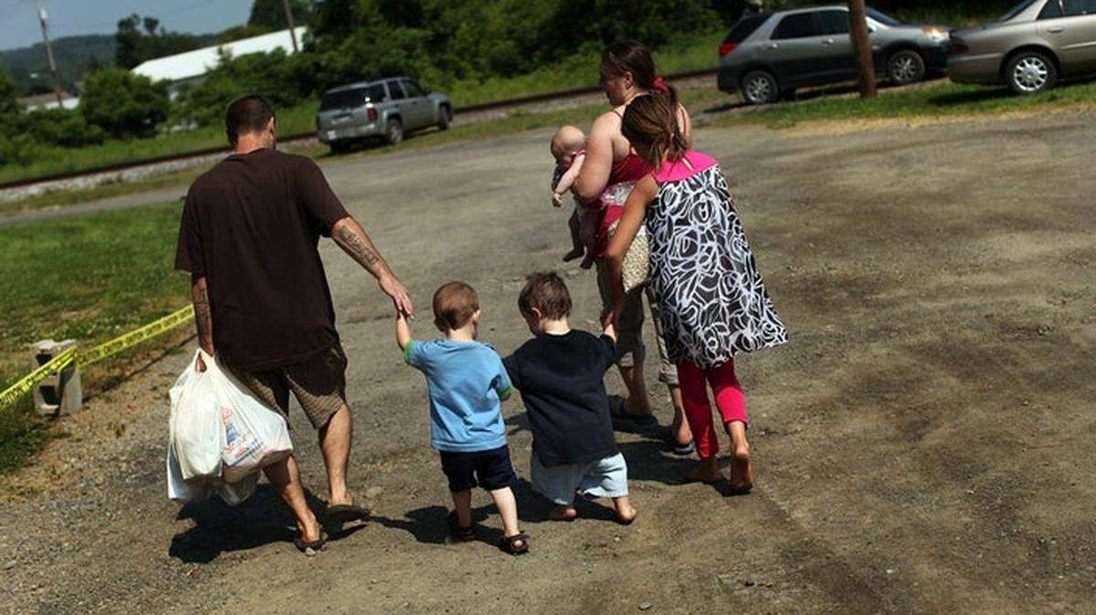 The coronavirus pandemic has exacerbated hunger in American families, such as this one leaving a mobile food pantry.